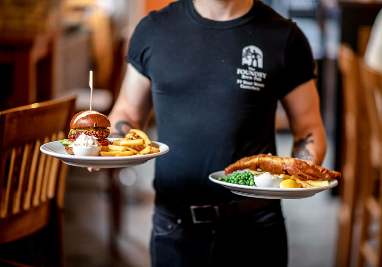 Waiter carrying plates, food, burger, fish and chips, foundry, pub food